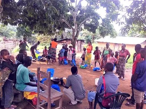 Membres d’une communauté réunis en assemblée sous les arbres