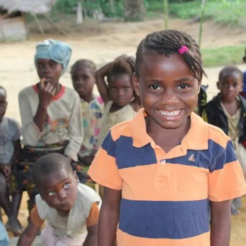 Une fillette souriante entourée d’enfants