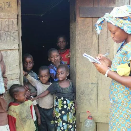 Une agente recense des enfants devant leur maison